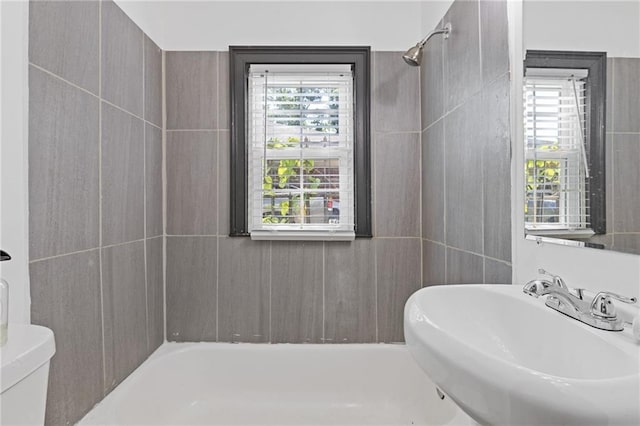 full bathroom with toilet, sink, and washtub / shower combination