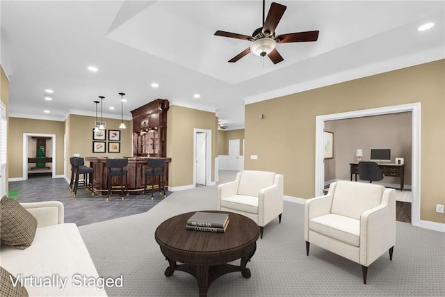 living room with bar, ceiling fan, carpet, and ornamental molding