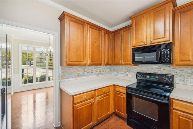 kitchen with black appliances, light hardwood / wood-style flooring, a notable chandelier, and crown molding