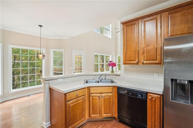 kitchen with black dishwasher, sink, light wood-type flooring, stainless steel fridge, and pendant lighting