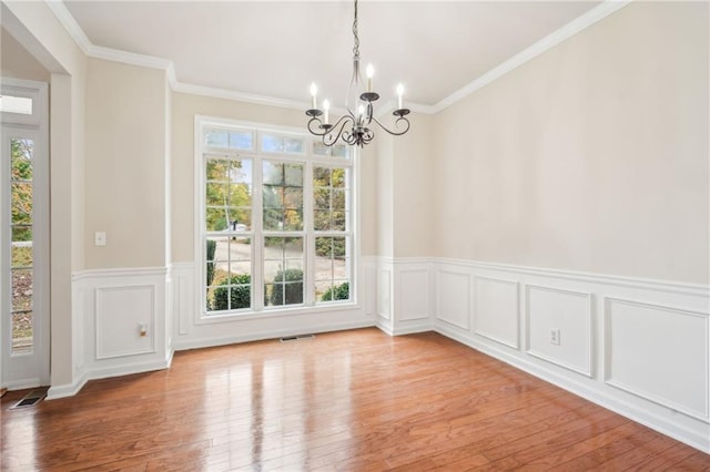 unfurnished dining area featuring light hardwood / wood-style flooring, an inviting chandelier, and plenty of natural light