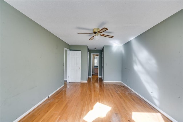 empty room with light hardwood / wood-style floors and ceiling fan