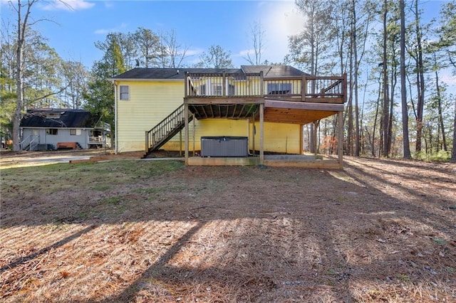 rear view of property featuring central AC, a hot tub, and a deck