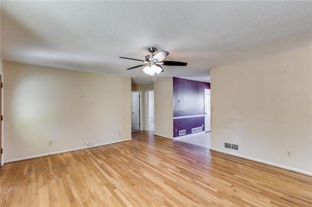 empty room with ceiling fan, a textured ceiling, and light hardwood / wood-style flooring