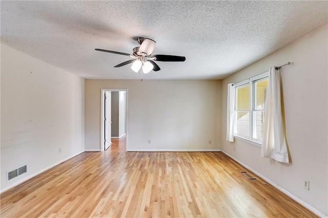 spare room with ceiling fan, a textured ceiling, and light wood-type flooring