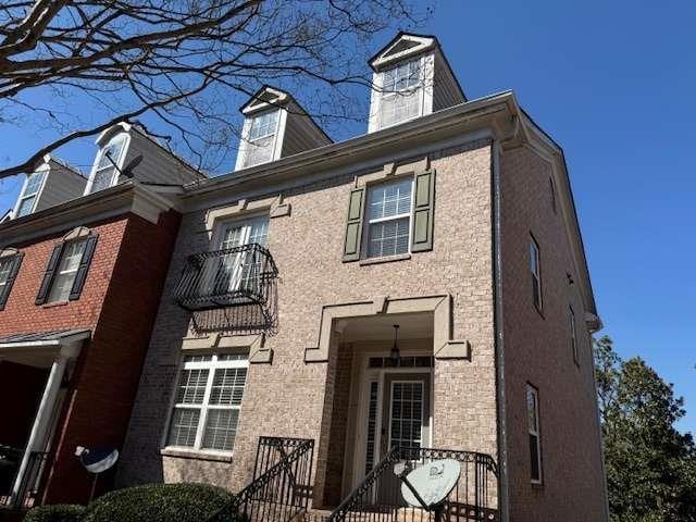 view of front of property featuring a gate and a balcony
