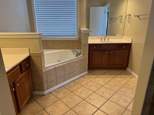 full bathroom featuring tile patterned floors, a bath, and vanity