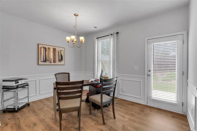 1311 Park Center Cir, Austell, GA 30168 - dining space featuring a chandelier, wood finished floors, a wainscoted wall, and a decorative wall