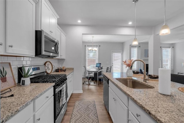 1311 Park Center Cir, Austell, GA 30168 - kitchen featuring appliances with stainless steel finishes, recessed lighting, white cabinetry, light wood finished floors, and pendant lighting