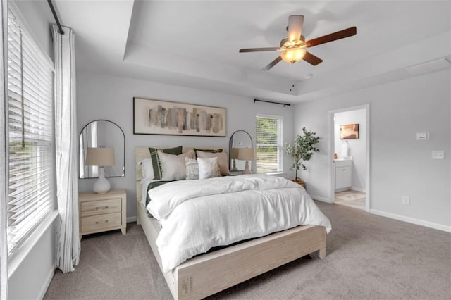 1311 Park Center Cir, Austell, GA 30168 - carpeted bedroom with a tray ceiling, ensuite bath, and a ceiling fan