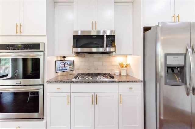 6828 New Fern Ln, Flowery Branch, GA 30542 - kitchen featuring appliances with stainless steel finishes, white cabinets, dark stone countertops, and backsplash