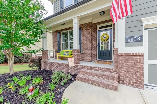 6828 New Fern Ln, Flowery Branch, GA 30542 - doorway to property featuring a porch and brick siding