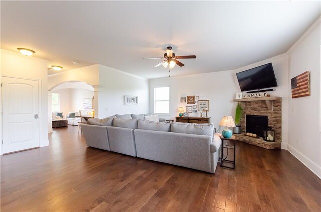 6828 New Fern Ln, Flowery Branch, GA 30542 - living area with ceiling fan, arched walkways, dark wood finished floors, a fireplace, and crown molding