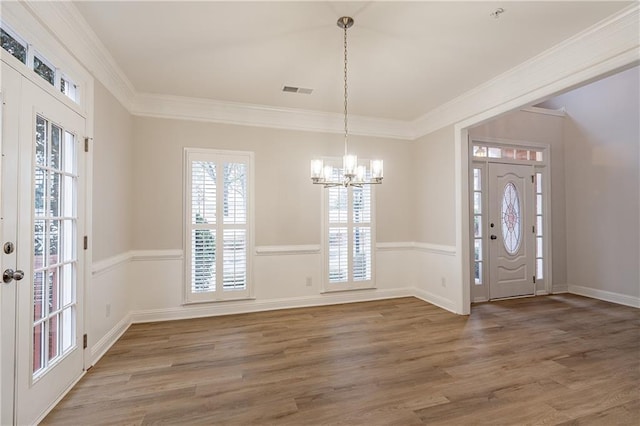 foyer featuring wood-type flooring, ornamental molding, and french doors