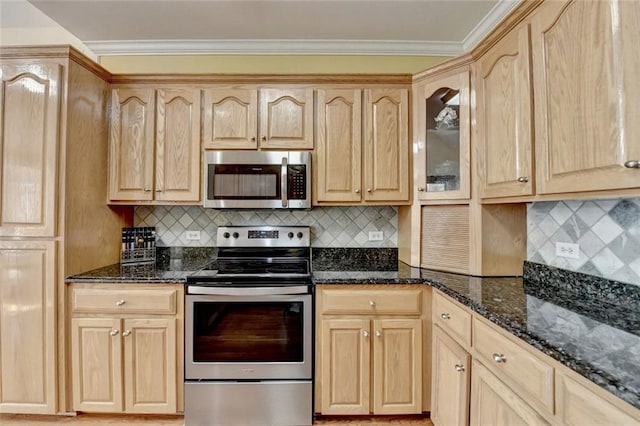 kitchen with ornamental molding, stainless steel appliances, light brown cabinetry, and dark stone countertops