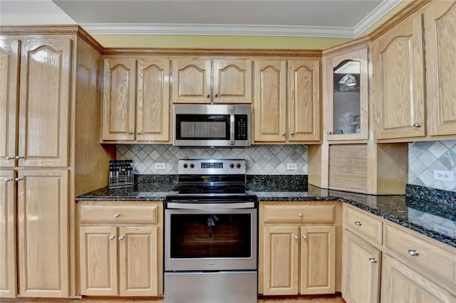 kitchen with dark stone counters, stainless steel appliances, light brown cabinetry, and crown molding