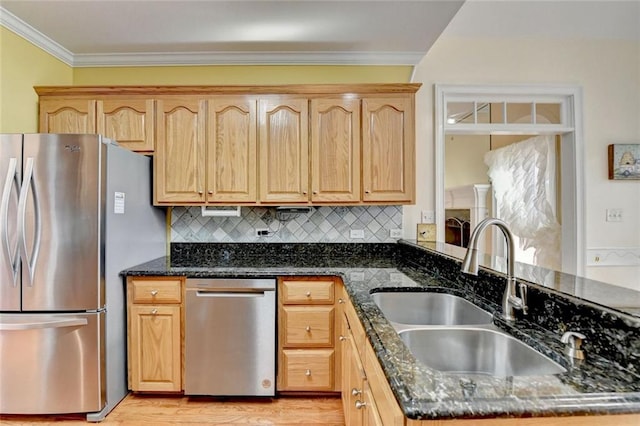 kitchen featuring stainless steel appliances, decorative backsplash, ornamental molding, a sink, and dark stone countertops