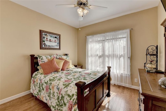 bedroom featuring baseboards, ceiling fan, and light wood-style floors