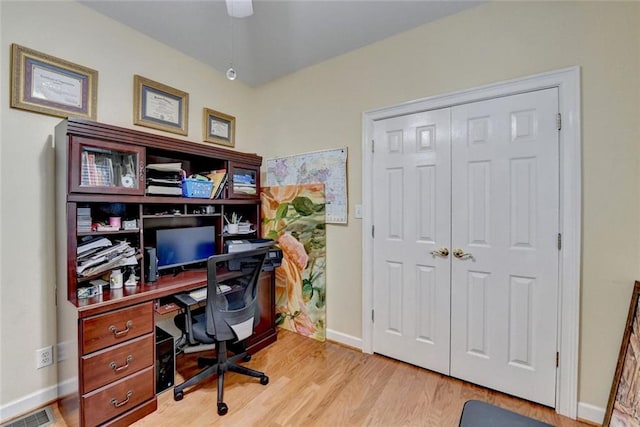 home office with light wood-type flooring, visible vents, and baseboards