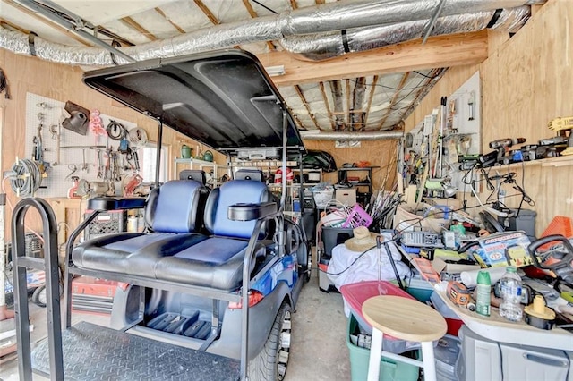 garage featuring wooden walls and a workshop area