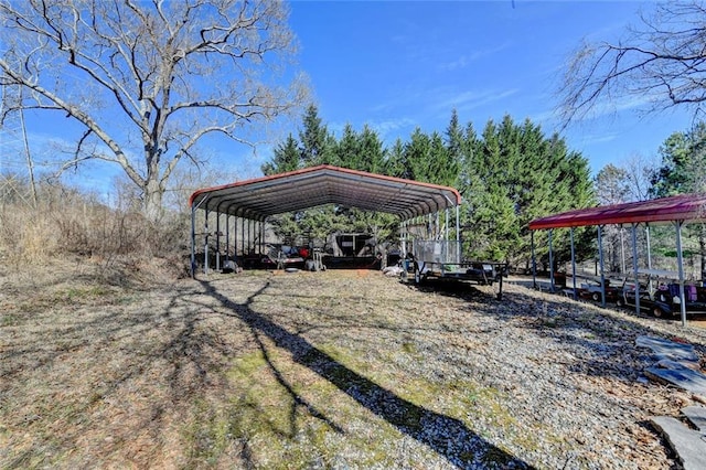 view of vehicle parking with dirt driveway and a detached carport