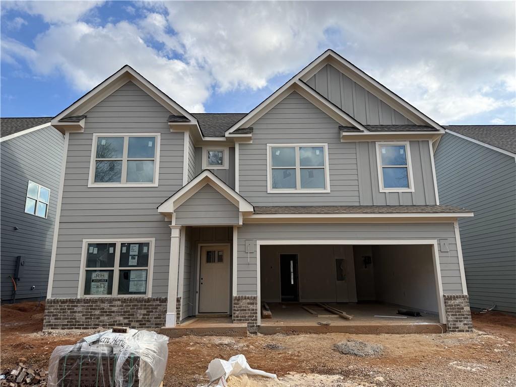 craftsman-style home featuring brick siding, board and batten siding, and an attached garage