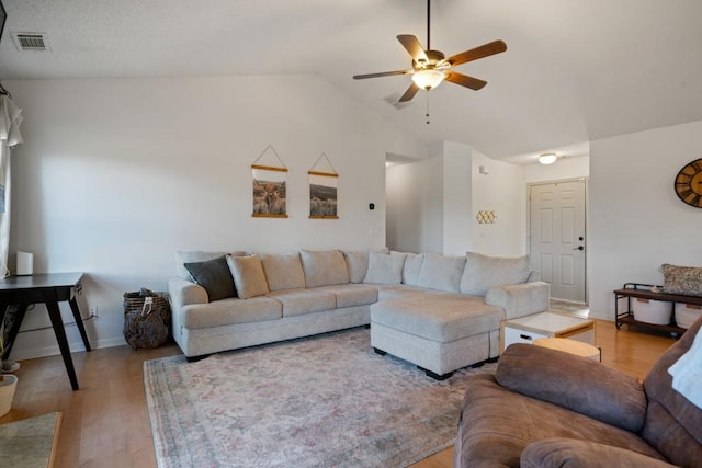 living area with lofted ceiling, light wood-style flooring, visible vents, baseboards, and a ceiling fan