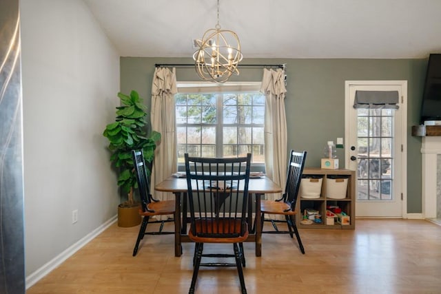 dining space with a chandelier, a wealth of natural light, and wood finished floors