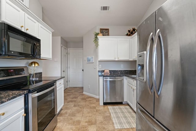 kitchen with stainless steel appliances, visible vents, baseboards, white cabinetry, and dark stone countertops