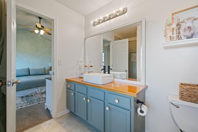 bathroom featuring toilet, a ceiling fan, vanity, ensuite bath, and tile patterned floors