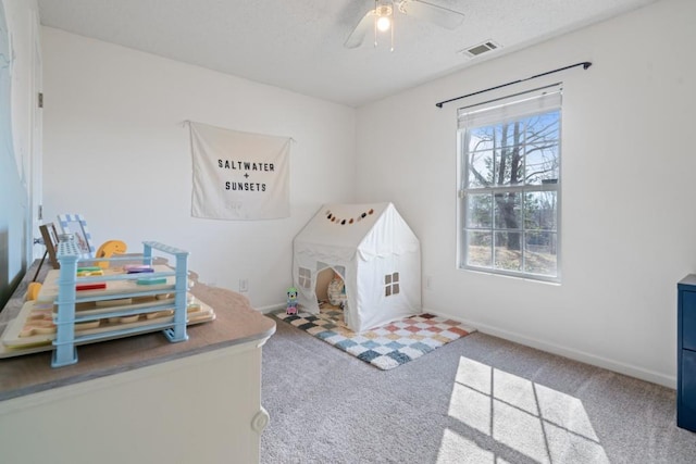 playroom with visible vents, baseboards, ceiling fan, a textured ceiling, and carpet flooring