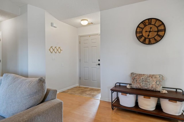 foyer with light wood-style floors and baseboards