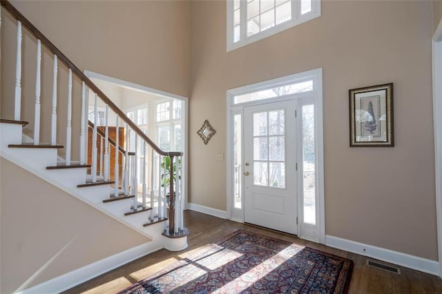 foyer entrance with hardwood / wood-style floors and a high ceiling