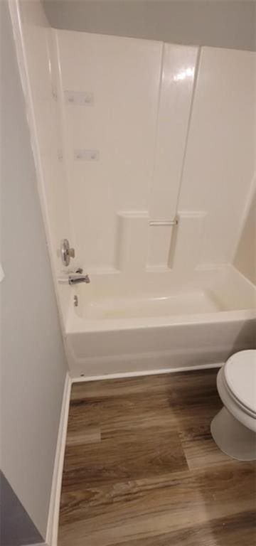 bathroom featuring hardwood / wood-style flooring, toilet, and shower / tub combination