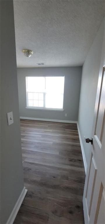 unfurnished room featuring dark wood-type flooring