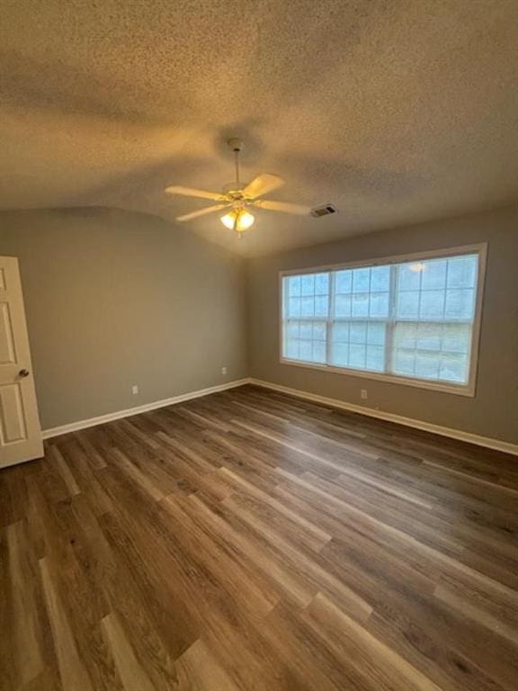 empty room featuring ceiling fan, dark hardwood / wood-style flooring, a textured ceiling, and vaulted ceiling