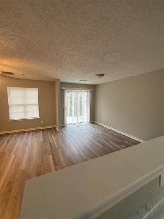 unfurnished room with a textured ceiling and hardwood / wood-style flooring