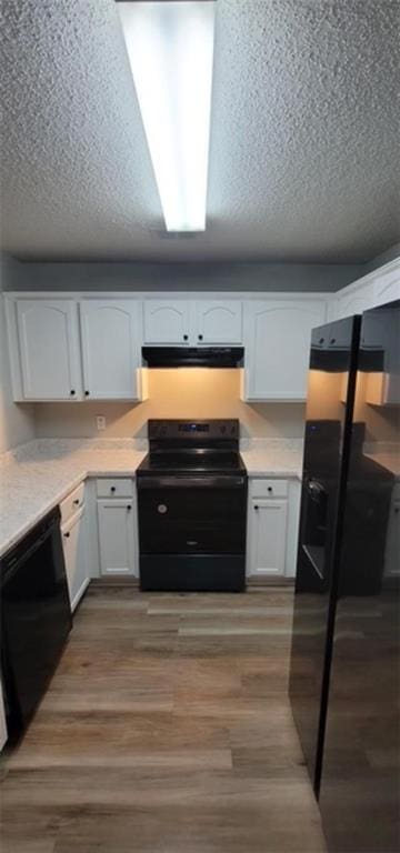 kitchen with white cabinetry, light hardwood / wood-style flooring, black appliances, and a textured ceiling