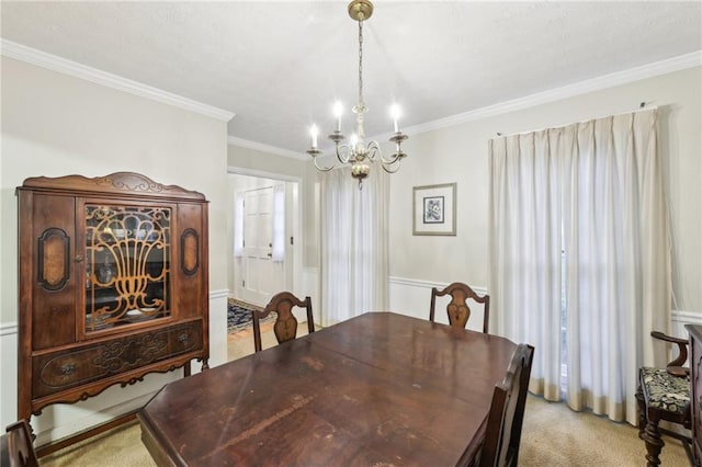 carpeted dining space with ornamental molding and a chandelier