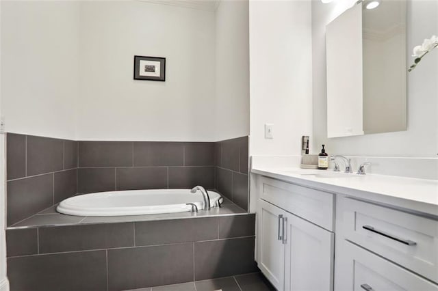 full bathroom with a garden tub, vanity, and tile patterned floors