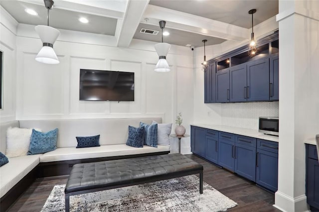 living room featuring visible vents, coffered ceiling, dark wood-style flooring, beamed ceiling, and a decorative wall