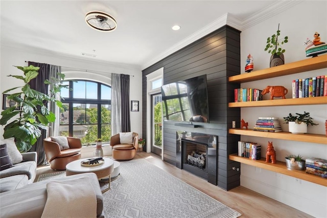 sitting room featuring ornamental molding, a fireplace, and light wood finished floors