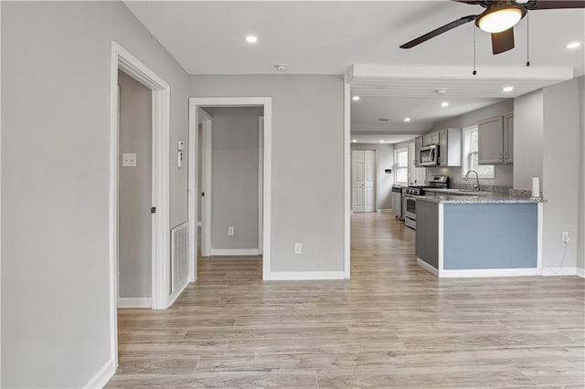 2309 Carver Dr NW, Atlanta, GA 30314 - kitchen with appliances with stainless steel finishes, a sink, ceiling fan, light wood finished floors, and baseboards