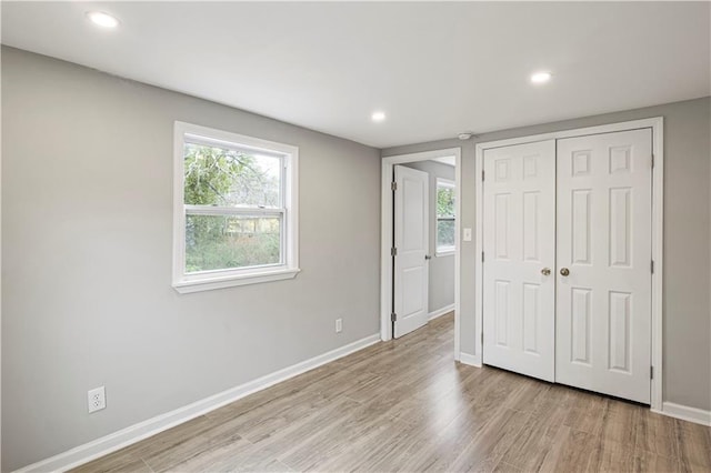 2309 Carver Dr NW, Atlanta, GA 30314 - unfurnished bedroom featuring a closet, baseboards, wood finished floors, multiple windows, and recessed lighting