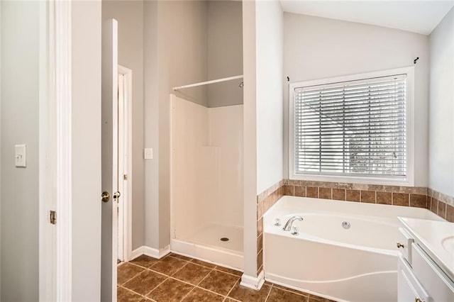 bathroom with tile patterned floors, vanity, and shower with separate bathtub