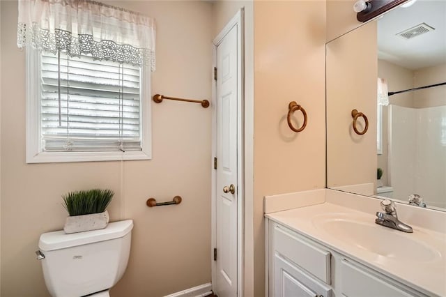 bathroom featuring a shower, vanity, and toilet