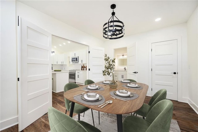 dining room with recessed lighting, dark wood-type flooring, baseboards, and a notable chandelier