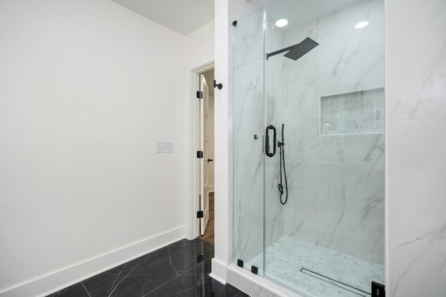 full bath featuring marble finish floor, baseboards, and a marble finish shower