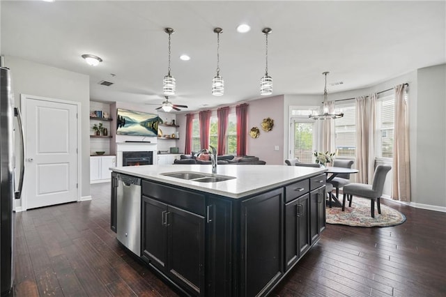 kitchen featuring a sink, dark cabinets, appliances with stainless steel finishes, dark wood-type flooring, and a ceiling fan