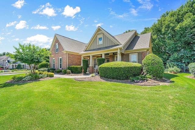7731 Sleepy Lagoon Way, Flowery Branch, GA 30542 - craftsman-style house featuring board and batten siding, a front yard, brick siding, and covered porch